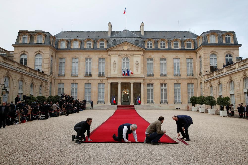 Workmen prepare the red carpet before a handover ceremony between French President-elect Emmanuel Macron and outgoing President Francois Hollande at the Elysee Palace in Paris, France, May 14, 2017. REUTERS/Christian Hartmann