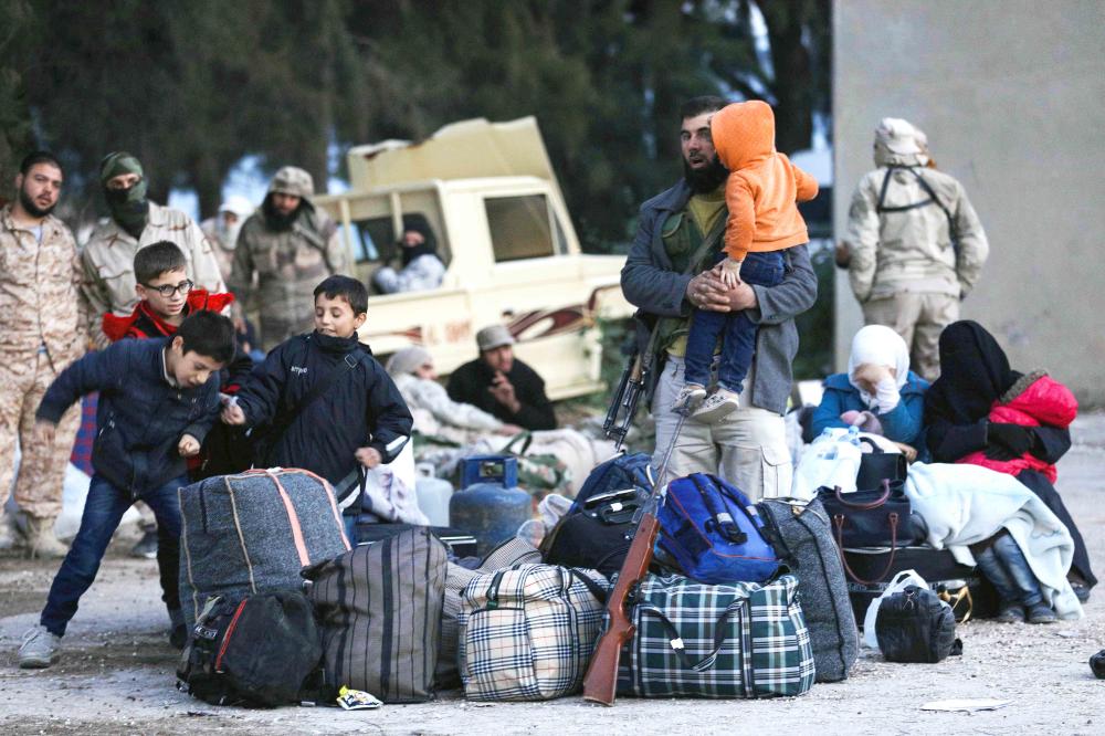 A convoy carrying opposition fighters and their families from the East Qalamun area, 60 kilometres (35 miles) northeast of Syria's capital, arrives in Qalaat al-Madiq, some 45 kilometres northwest of the central city of Hama, on April 23, 2018, after they were evacuated under a deal between opposition fighters and the Russia-backed regime. Under the deal, several thousand anti-government fighters and their relatives are to be granted safe passage from East Qalamun to rebel-held territory in the north.  / AFP / OMAR HAJ KADOUR
