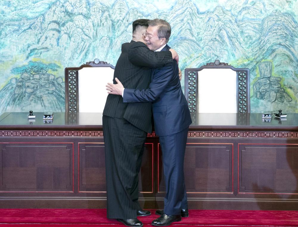 epa06696276 North Korean leader Kim Jong-Un (L) hugs with South Korean President Moon Jae-In (R) after signing a document at the Joint Security Area (JSA) on the Demilitarized Zone (DMZ) in the border village of Panmunjom in Paju, South Korea, 27 April 2018. South Korean President Moon Jae-in and North Korean leader Kim Jong-un are meeting at the Peace House in Panmunjom for an inter-Korean summit. The event marks the first time a North Korean leader has crossed the border into South Korea since the end of hostilities during the Korean War. EPA/KOREA SUMMIT PRESS / POOL