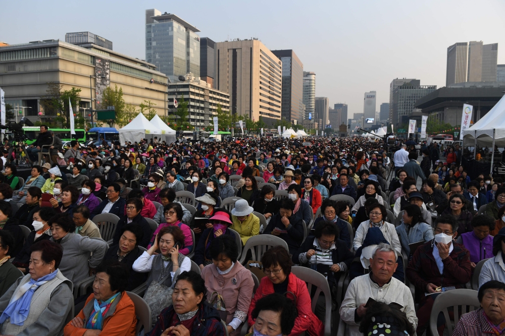 Buddhist followers attend a rally to pray for the success of the inter-Korean summit, in Seoul on April 27, 2018. The leader of nuclear-armed North Korea Kim Jong Un and the South's President Moon Jae-in said they were committed to the denuclearisation of the Korean peninsula after a historic summit on April 27. / AFP / GREG BAKER
