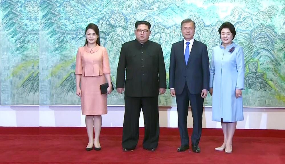 This screen grab from the Korean Broadcasting System (KBS) taken on April 27, 2018 shows North Korea's leader Kim Jong Un (2nd L) and his wife Ri Sol Ju (L) posing for a photo with South Korea's President Moon Jae-in (2nd R) and his wife Kim Jung-sook (R) at the end of their historic summit at Panmunjom. The leaders of the two Koreas held a landmark summit on April 27 after a highly symbolic handshake over the Military Demarcation Line that divides their countries, with the North's Kim Jong Un declaring they were at the 