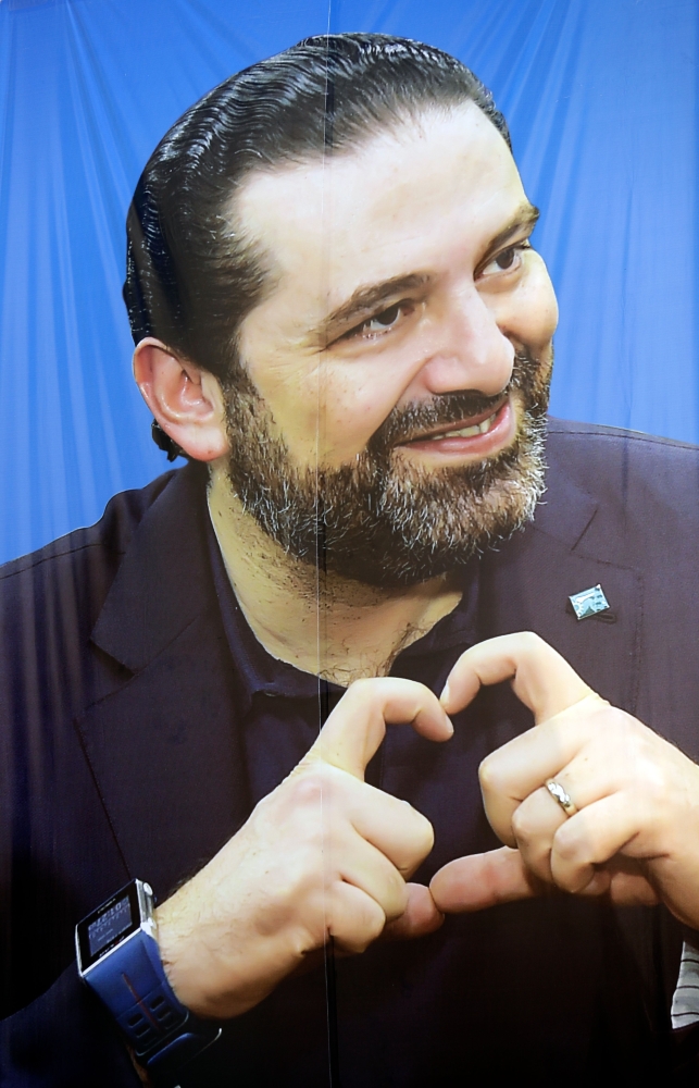 A picture taken on April 18, 2018 shows an electoral banner of Lebanese Prime Minister and candidate for the upcoming parliamentary elections Saad Hariri hanging on a building in the capital Beirut. For decades the same families have played a pivotal role in the small Middle Eastern country, officially ruled by a parliamentary democratic system but where political power is still informally handed down through generations. / AFP / JOSEPH EID
