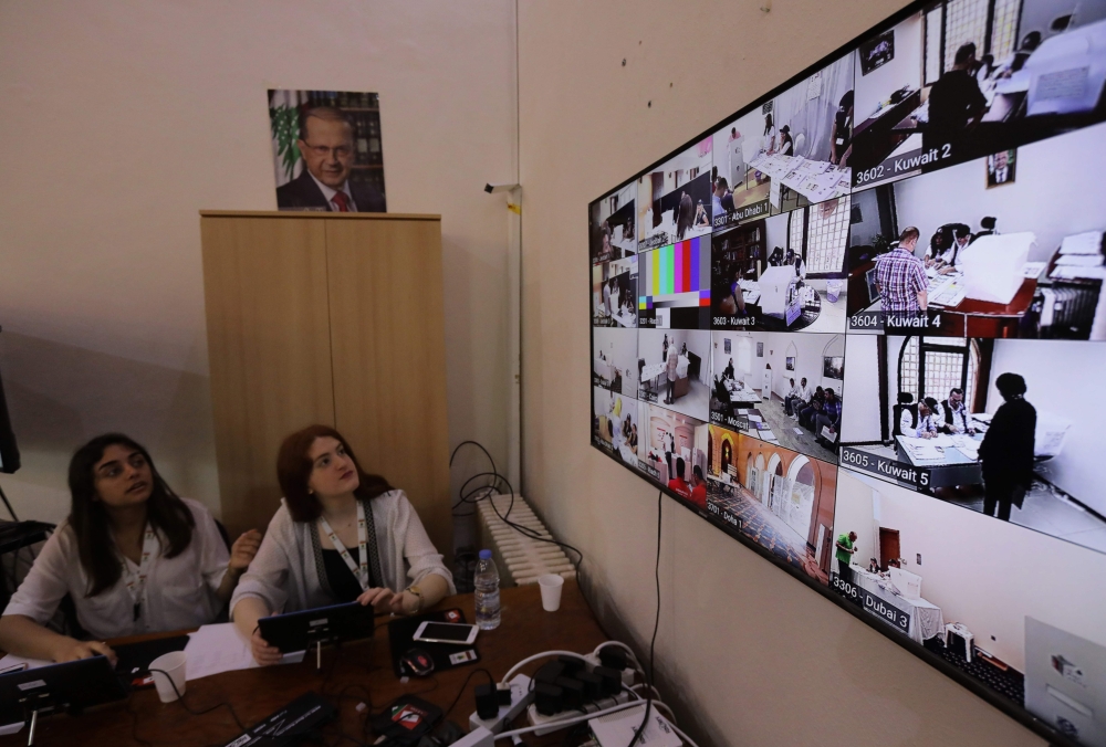 Members of Lebanon's electoral commission monitor screens bearing images of embassies around the Middle East at the Ministry of Foreign Affairs in Beirut to check the electoral process as Lebanese expats start voting in the Lebanese parliamentary elections on April 27, 2018. The 12,611 Lebanese voters registered in the Middle East will be the first to cast ballots for the 128 seats in Lebanon's parliament. / AFP / ANWAR AMRO
