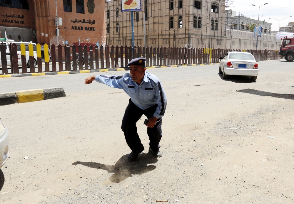 epa06716422 A Yemeni policeman reacts after an alleged Saudi-led airstrike that hit the presidential palace in Sana'a, Yemen, 07 May 2018. According to reports, two Saudi-led airstrikes targeted the presidential palace in Sana'a, killing at least six people and wounding more than 30 others.  EPA/YAHYA ARHAB