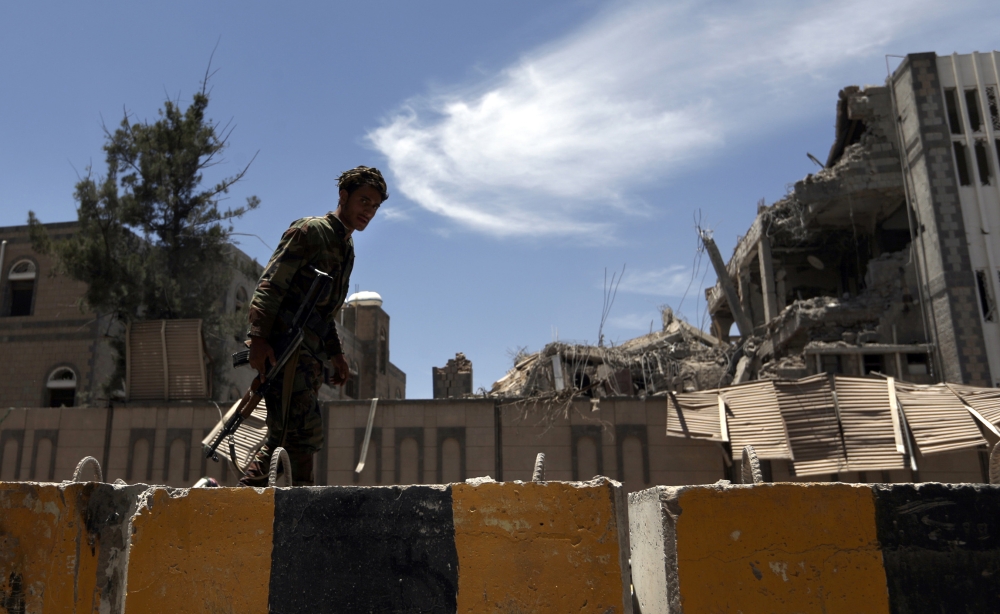 Yemenis check the site of air strikes at the president office in the capital Sanaa on May 7, 2018. Two air raids targeted the office of the presidency in Yemen's rebel-held capital Sanaa, leaving at least six people killed and 30 wounded, a medical source told AFP.  / AFP / Mohammed HUWAIS
