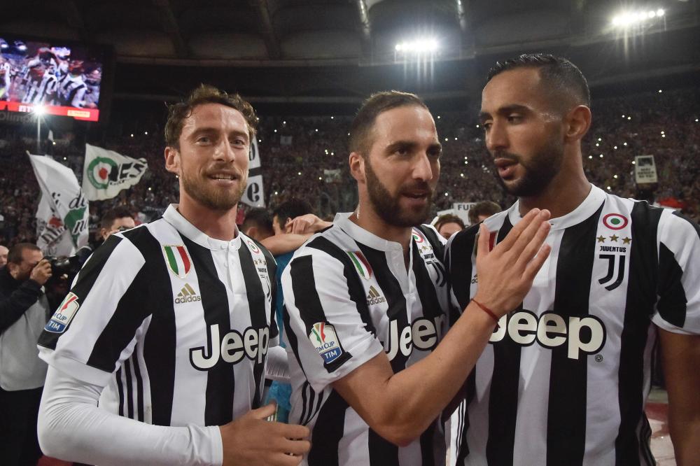 Juventus' midfielder Claudio Marchisio, Juventus' forward from Argentina Gonzalo Higuain (C) and Juventus' defender from Italy Medhi Benatia (R) celebrate after winning the Italian Tim Cup (Coppa Italia) final Juventus vs AC Milan at the Olympic stadium on May 9, 2018 in Rome. Juventus crushed AC Milan 4-0 on today at the Stadio Olimpico to win a fourth consecutive Italian Cup. Mehdi Benatia opened the floodgates after 56 minutes for the first of a double of the night for the Moroccan with Douglas Costa also finding the net in the space of nine minutes. A Nikola Kalinic own goal accounted for the fourth
 / AFP / TIZIANA FABI
