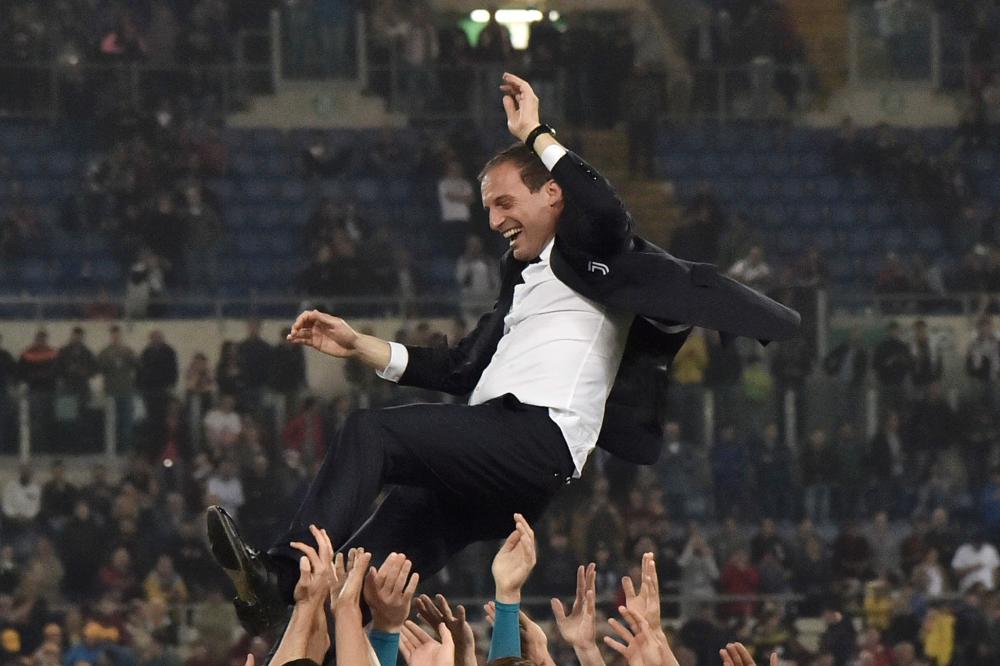 Juventus' players lift Juventus' coach from Italy Massimiliano Allegri after winning the Italian Tim Cup (Coppa Italia) final Juventus vs AC Milan at the Olympic stadium on May 9, 2018 in Rome. Juventus crushed AC Milan 4-0 on today at the Stadio Olimpico to win a fourth consecutive Italian Cup. Mehdi Benatia opened the floodgates after 56 minutes for the first of a double of the night for the Moroccan with Douglas Costa also finding the net in the space of nine minutes. A Nikola Kalinic own goal accounted for the fourth
 / AFP / TIZIANA FABI
