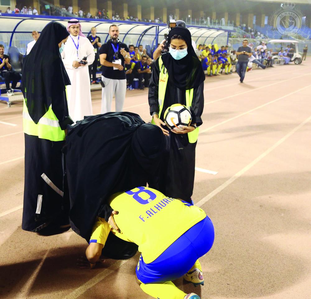 



الهريفي مقبلاً قدمي والدته التي قامت بقص شريط حفلة اعتزاله أمس. (تصوير: عبدالعزيز السلامة)