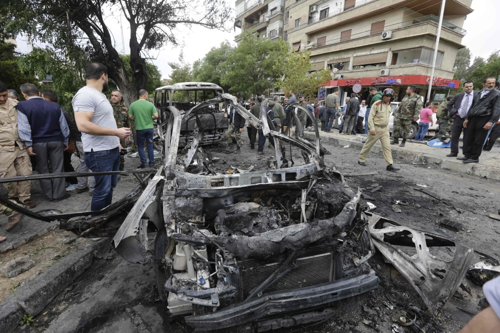 Syrians check the site of an explosion in the capital Damascus on May 9, 2018.  A shelling and a car bomb blast in Syria's capital Damascus killed two people and wounded several others today, state television said. It reported 