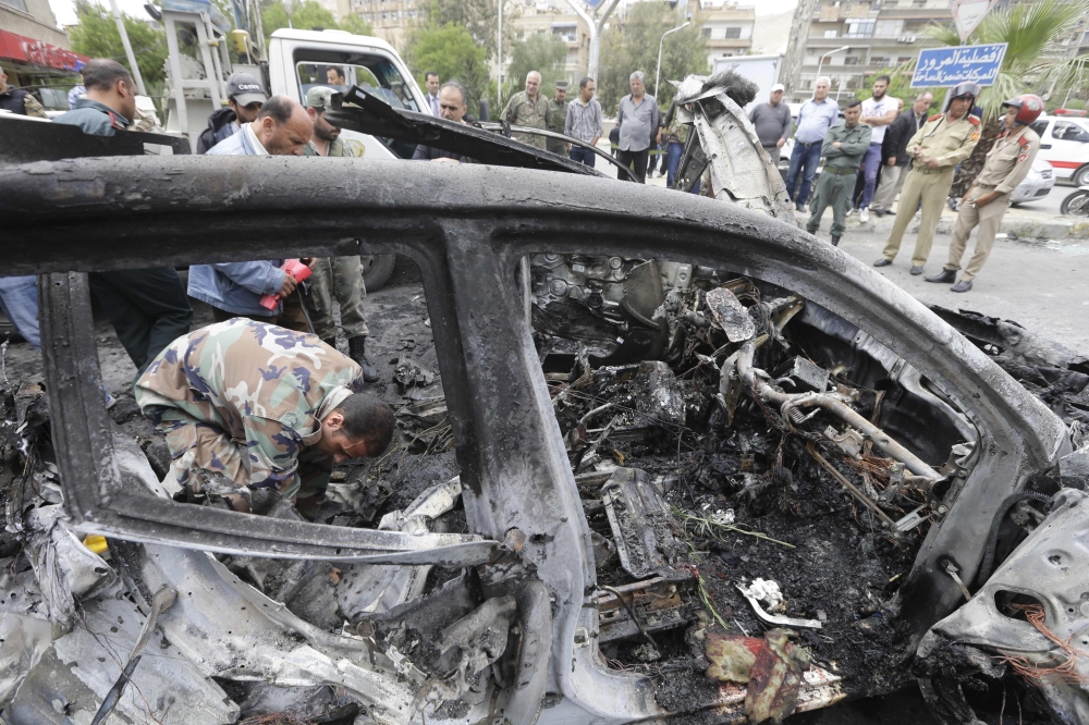 Syrians check the site of an explosion in the capital Damascus on May 9, 2018.  A shelling and a car bomb blast in Syria's capital Damascus killed two people and wounded several others today, state television said. It reported 