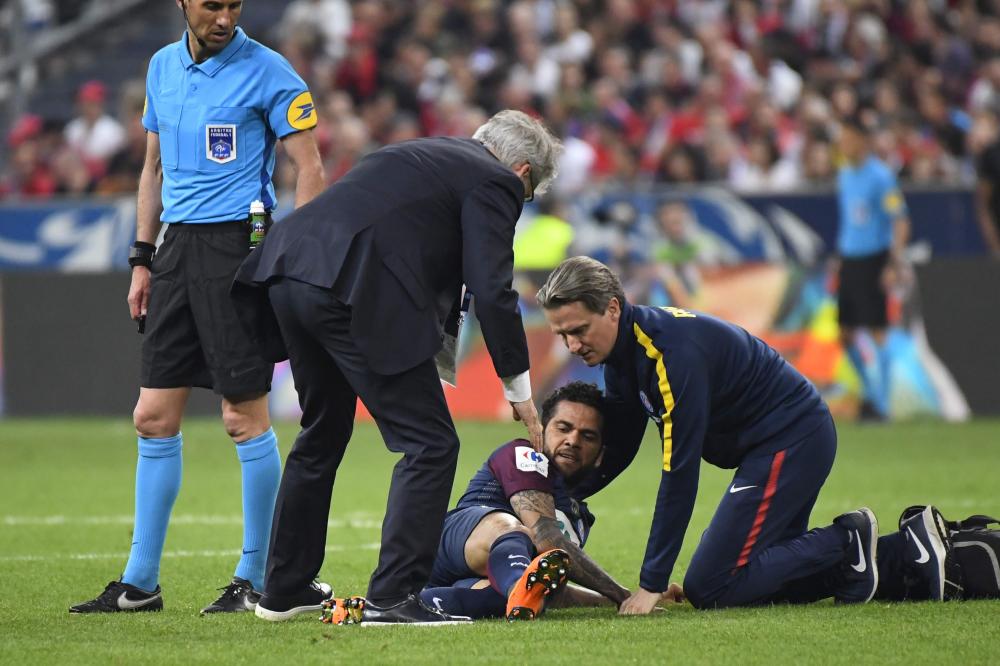 (FILES) In this file photo taken on May 08, 2018 showing Paris Saint-Germain's Brazilian defender Daniel Alves (C) receiving medical assistance during the French Cup final football match between Les Herbiers and Paris Saint-Germain (PSG) at the Stade de France in Saint-Denis, outside Paris. Brazil defender Dani Alves ruled out of World Cup on May 11, 2018, due to an injure, according to the Brazilian Football Confederation. / AFP / Damien MEYER
