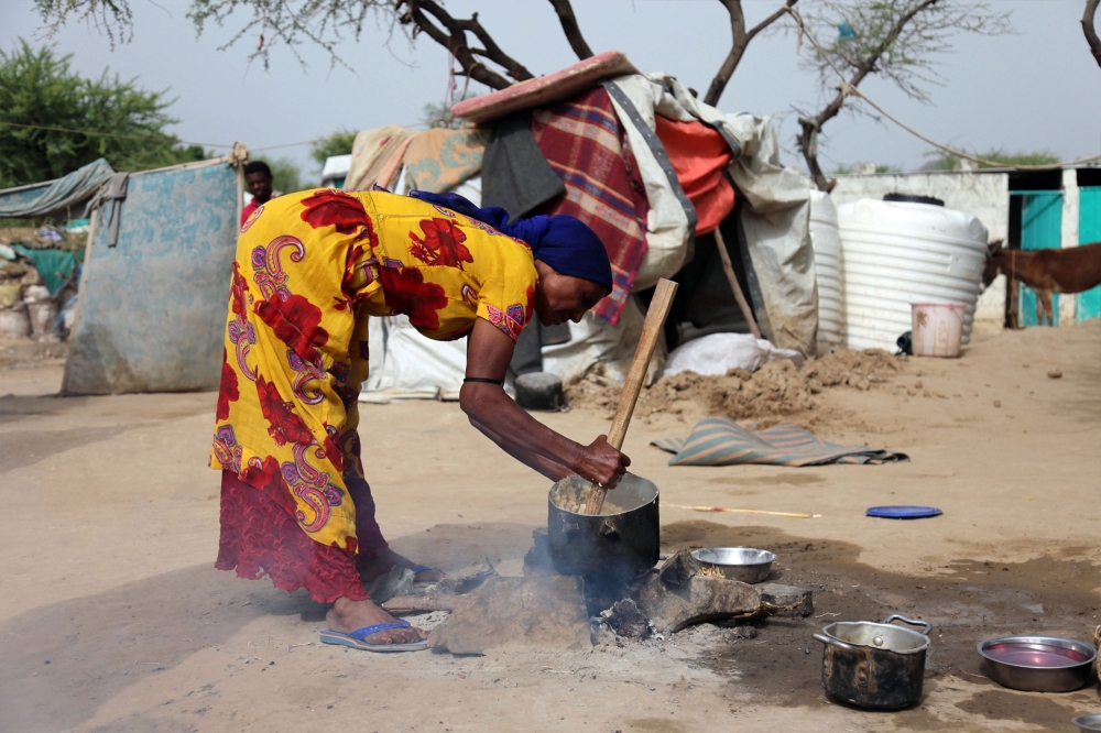 TOPSHOT - A displaced Yemeni woman cooks a meal at a make-shift camp for displaced people where they are taking shelter in the Maafir area, on the outskirts of Yemen's Taez province on May 12, 2018.  / AFP / Ahmad AL-BASHA
