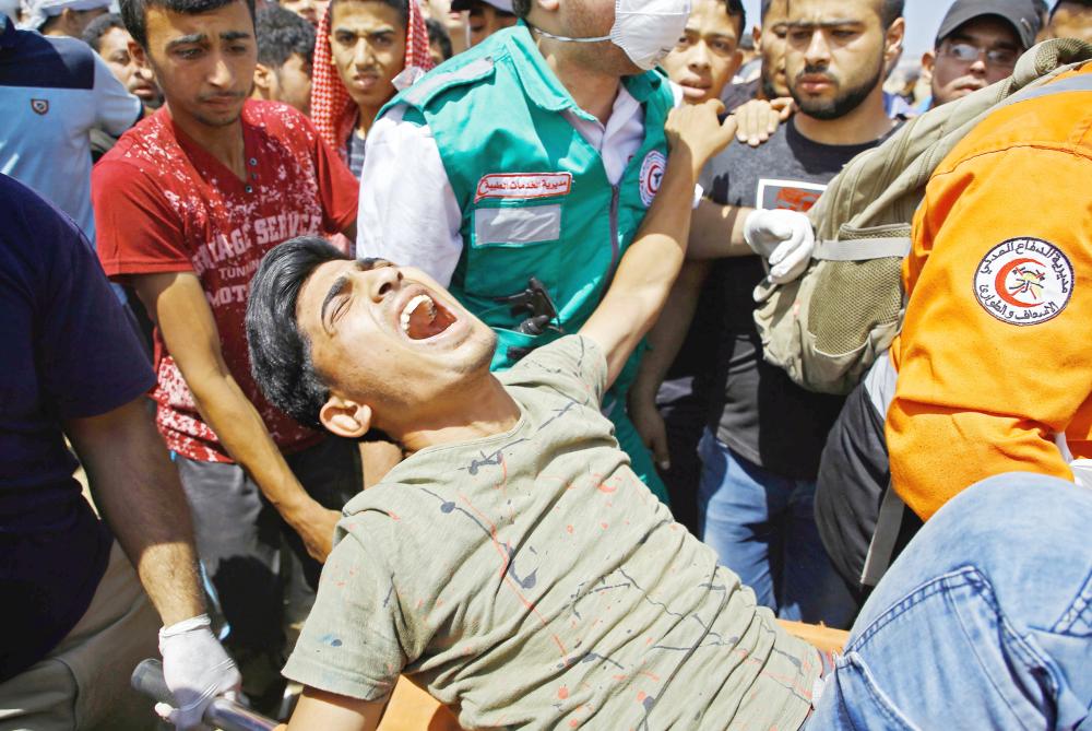 



جريح فلسطيني سقط خلال اشتباكات مع قوات الاحتلال على الحدود الفاصلة مع غزة، خلال احتجاجات فتح سفارة أمريكا في القدس. (أ ف ب)
