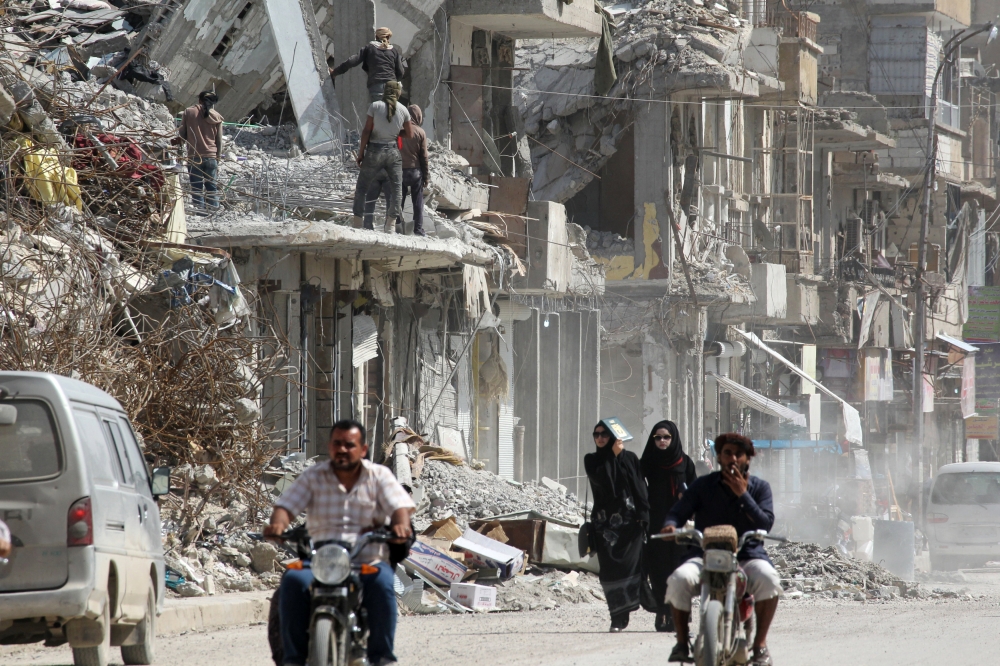 Women walk past rubble of damaged buildings in Raqqa, Syria May 14, 2018. REUTERS/Aboud Hamam