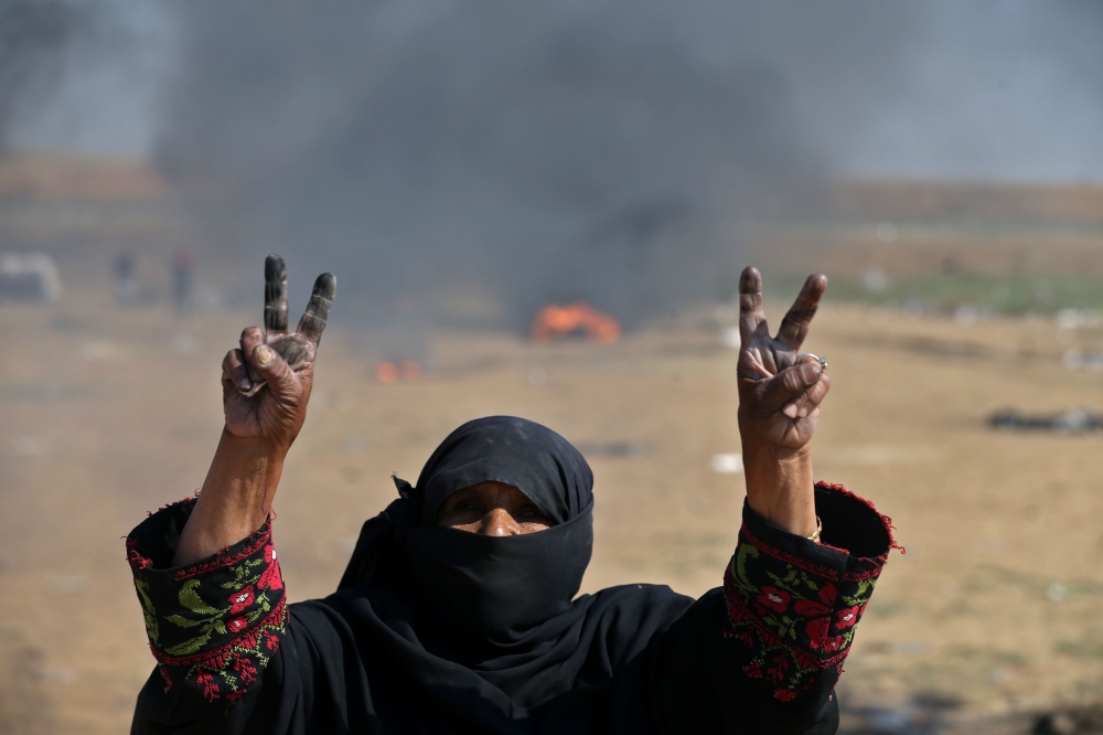 TOPSHOT - A Palestinian woman flashes the 