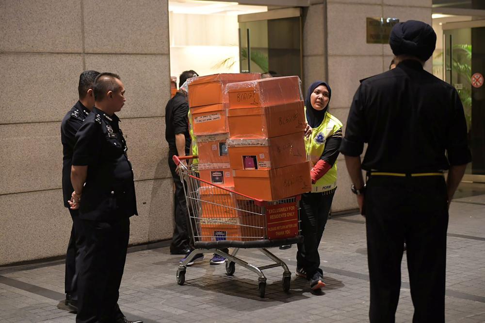 A Malaysian police officer pushes a trolley during a raid of three apartments in a condominum owned by former Malaysian prime minister Najib Razak’s family, in Kuala Lumpur, May 17, 2018, in this photo taken by The Straits Times. Picture taken May 17, 2018. Ariffin Jamar/The Straits Times via REUTERS ATTENTION EDITORS -  THIS IMAGE HAS BEEN SUPPLIED BY A THIRD PARTY.  SINGAPORE OUT. NO COMMERCIAL OR EDITORIAL SALES IN SINGAPORE.  FOR EDITORIAL USE ONLY. NO RESALES. NO ARCHIVES.