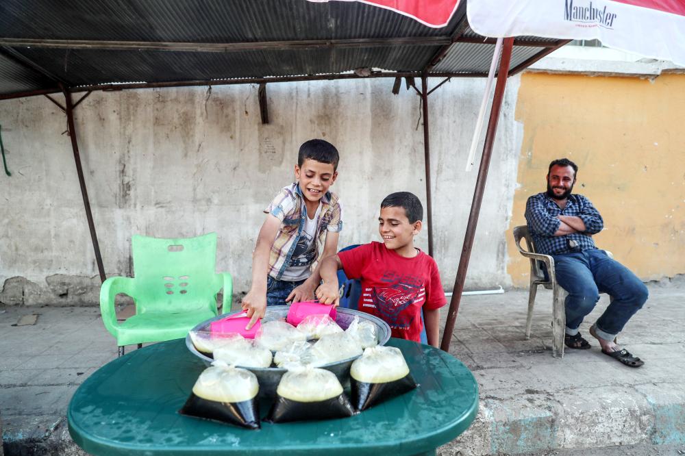 



طفلان يلهوان حول بسطة لبيع شراب العرقسوس في عفرين.