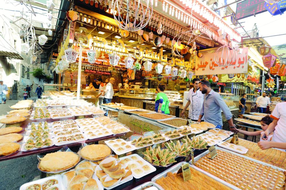 



سوريون يبيعون الحلوى في أحد أسواق حي الميدان بالعاصمة دمشق أمس.  (إي ب أ)