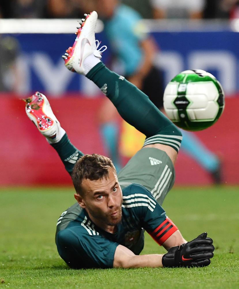 Russia's Igor Akinfeev makes a save during their international friendly football match between Austria and Russia at Tivoli stadium in Innsbruck, Austria on May 30, 2018.  / AFP / JOE KLAMAR
