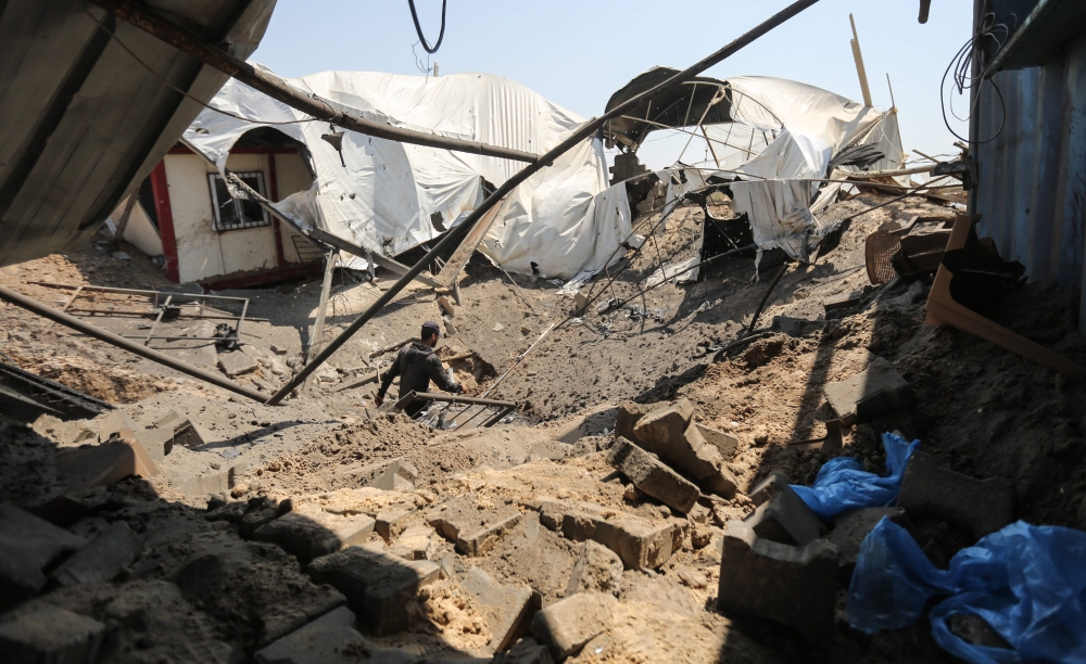 A man inspects the damage at a site targeted by an Israeli air strike a day before in Khan Younis in the southern Gaza strip on May 30, 2018. Israel said it targeted some 65 militant sites in the Gaza Strip a day earlier and into the early morning hours and around 100 rockets and mortars fired from Gaza either exploded in Israel or were intercepted by air defences, in the worst military flare-up since a 2014 war.  / AFP / MAHMUD HAMS
