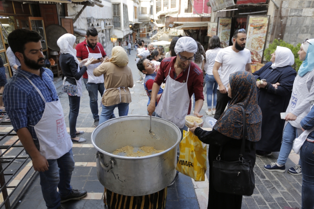 epa06774417 Young Syrians, many of them members of civil societies, prepare food for fasting people in the old city of Damascus, Syria, 30 May 2018, the 14th day of the Muslims' holy month of Ramadan.  Muslims around the world celebrate the holy month of Ramadan by praying during the night time and abstaining from eating and drinking during the period between sunrise and sunset. Ramadan is the ninth month in the Islamic calendar and it is believed that the Koran's first verse was revealed during its last 10 nights.  EPA/YOUSSEF BADAWI