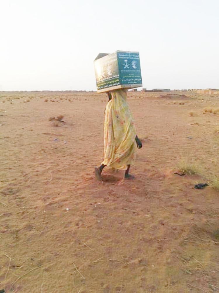 



سودانية تحمل على رأسها صندوق إغاثة من مركز الملك سلمان. (عكاظ)