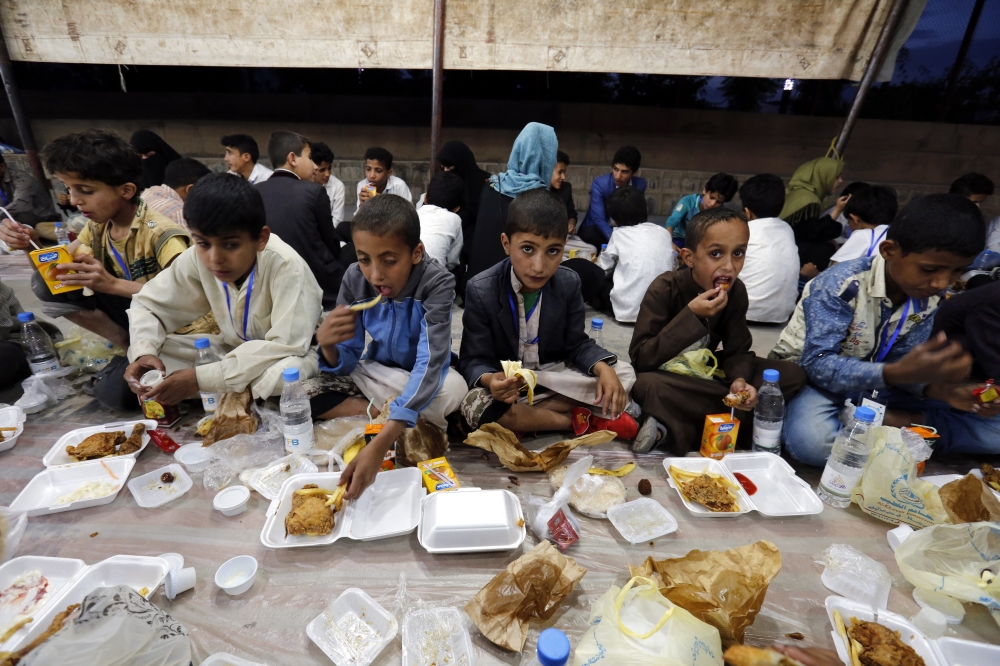 epa06799479 Yemeni orphans eat a meal during a banquet as part of a charity program for orphans during the Muslim fasting month of Ramadan in Sana'a, Yemen, 10 June 2018. Muslims around the world celebrate the holy month of Ramadan by praying during the night time and abstaining from eating, drinking, and sexual acts during the period between sunrise and sunset. Ramadan is the ninth month in the Islamic calendar and it is believed that the revelation of the first verse in Koran was during its last 10 nights. EPA/YAHYA ARHAB