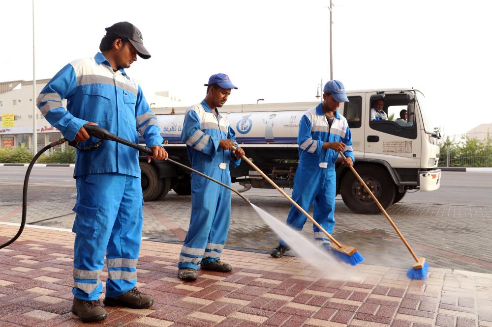 



عمال البلدية خلال تنظيف أحد الأحياء. (عكاظ)