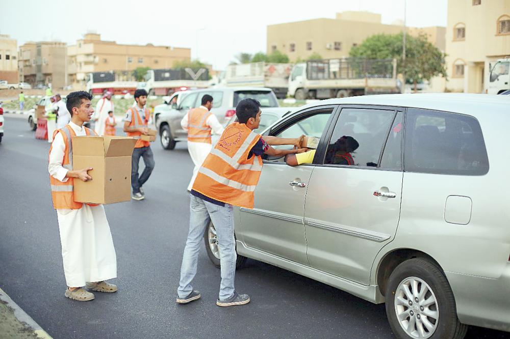 





متطوعون يوزعون وجبات الإفطار على العابرين. (عكاظ)