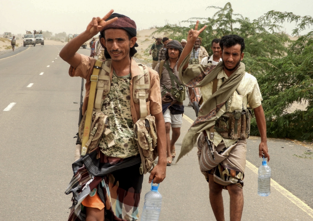 Yemeni pro-government forces flash the victory gesture as they arrive in al-Durayhimi district, about nine kilometres south of Hodeidah international airport on June 13, 2018. Yemeni forces backed by the Saudi-led coalition launched an offensive on June 13 to retake the rebel-held Red Sea port city of Hodeida, pressing toward the airport south of the city.
The port serves as the entry point for 70 percent of the impoverished country's imports as it teeters on the brink of famine. / AFP / NABIL HASSAN
