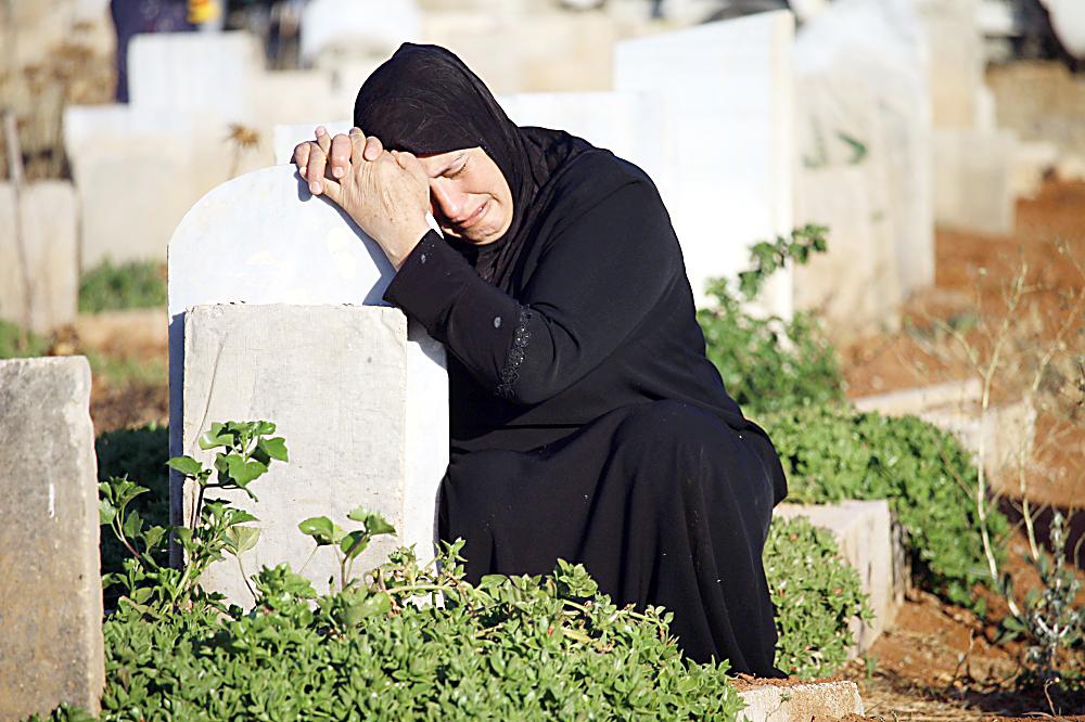 



سورية تبكي حزنا أمام قبر أحد ضحايا الحرب السورية بعد صلاة عيد الفطر في درعا، أمس. (أ.ف.ب)