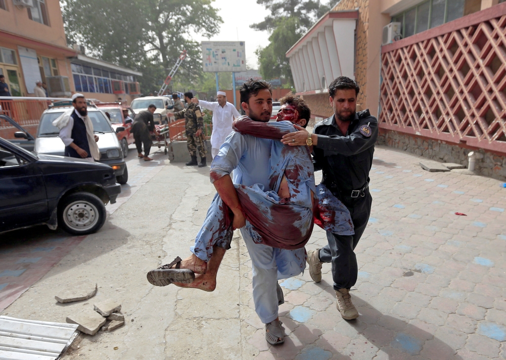 ATTENTION EDITORS - VISUAL COVERAGE OF SCENES OF INJURY OR DEATH   Men carry an injured man to a hospital after a car bomb in Jalalabad city, Afghanistan June 17, 2018. REUTERS/Parwiz   TEMPLATE OUT