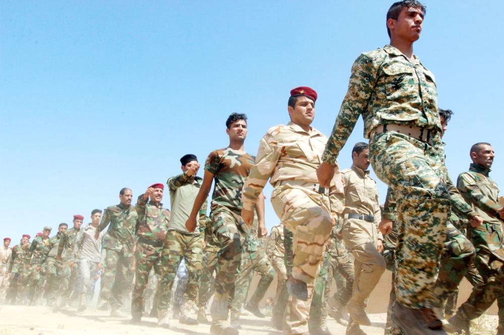 FILE PHOTO: Popular Mobilisation Forces (PMF) march during a military parade in Daquq, nearby Kirkuk, Iraq August 5, 2017. REUTERS/Ako Rasheed/File Photo