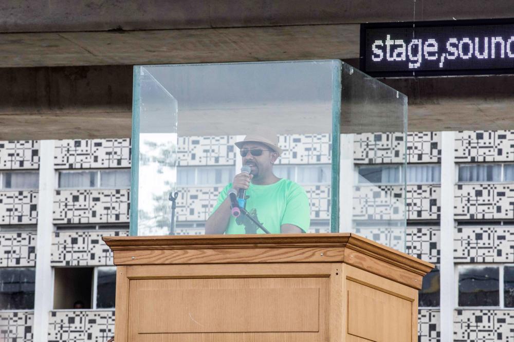 Ethiopia Prime Minister Abiy Ahmed delivers a speach behind a glass during a rally on Meskel Square in Addis Ababa on June 23, 2018. A blast at a rally in Ethiopia's capital today in support of new Prime Minister Abiy Ahmed killed several people, state media quoted the premier as saying. / AFP / YONAS TADESE
