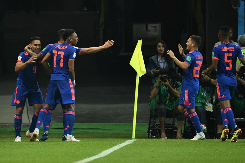 Colombia's forward Falcao (L) celebrates with teammates after scoring their second goal during the Russia 2018 World Cup Group H football match between Poland and Colombia at the Kazan Arena in Kazan on June 24, 2018. RESTRICTED TO EDITORIAL USE - NO MOBILE PUSH ALERTS/DOWNLOADS
 / AFP / SAEED KHAN / RESTRICTED TO EDITORIAL USE - NO MOBILE PUSH ALERTS/DOWNLOADS
