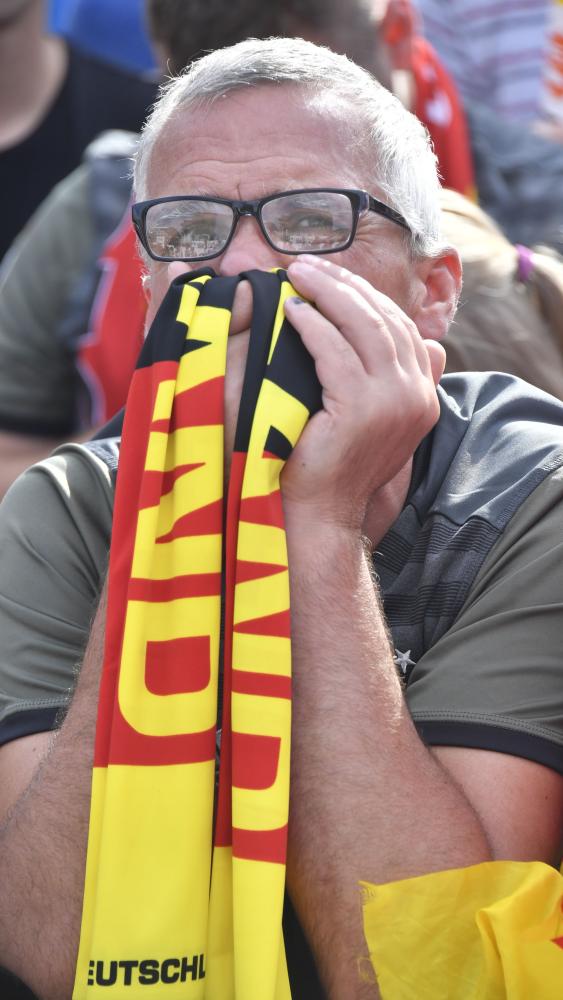 A supporter of the German national football team reacts during a public viewing event at the Fanmeile in Berlin to watch the Russia 2018 World Cup Group F football match between Germany and South Korea where the reigning world champions were defeated 0-2 on June 27, 2018. / AFP / John MACDOUGALL
