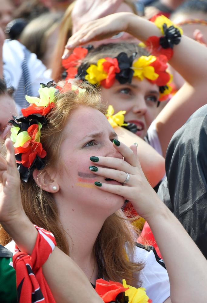 Supporters of the German national football react at a public viewing event at the Fanmeile in Berlin to watch the Russia 2018 World Cup Group F football match between South Korea and Germany where the reigning world champions were defeated 0-2 on June 27, 2018. / AFP / John MACDOUGALL
