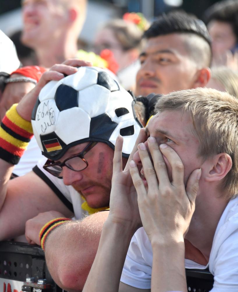 Supporters of the German national football team react as they attend a public viewing event at the Fanmeile in Berlin to watch the Russia 2018 World Cup Group F football match between South Korea and Germany on June 27, 2018. / AFP / John MACDOUGALL
