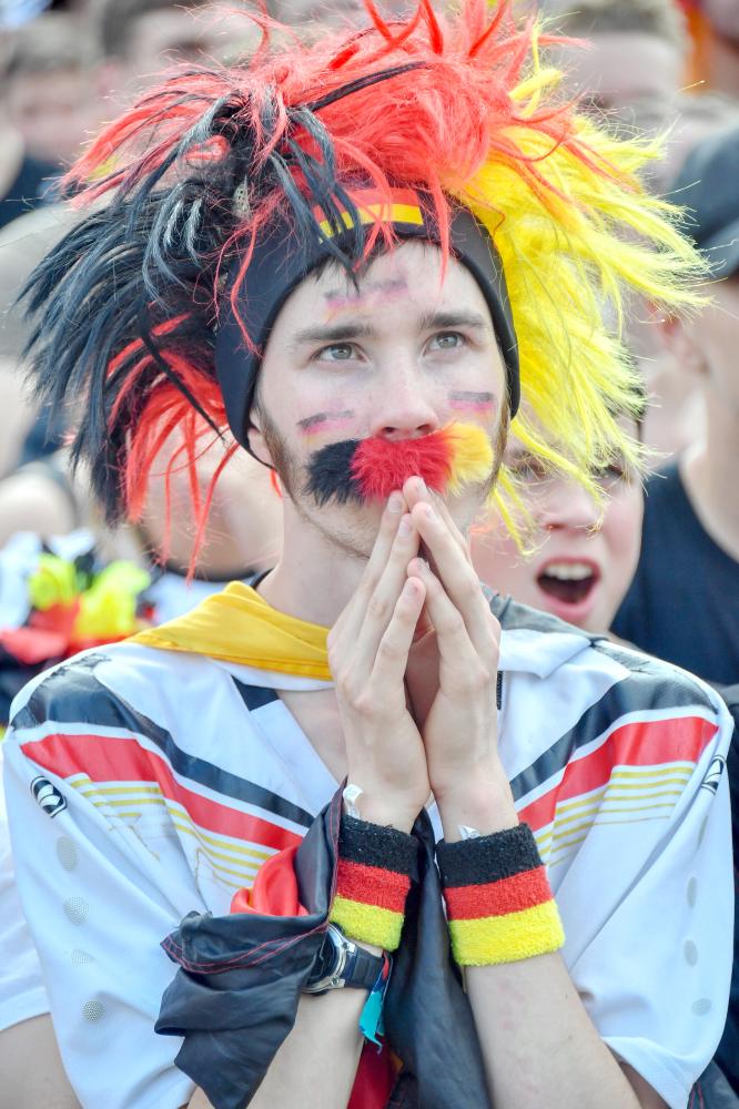 Supporters of the German national football react at a public viewing event at the Fanmeile in Berlin to watch the Russia 2018 World Cup Group F football match between South Korea and Germany where the reigning world champions were defeated 0-2 on June 27, 2018. / AFP / John MACDOUGALL
