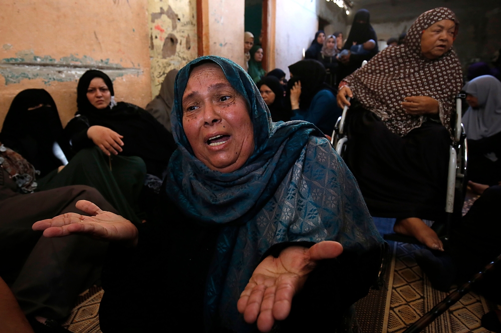 Palestinians mourn over the death of 24-year-old Mohammed al-Hamayda, during his funeral in Rafah in the Southern Gaza Strip on June 30, 2018. Israeli troops shot dead two Palestinians, one in his early teens, in border clashes in the southern Gaza Strip, the Hamas-ruled territory's health ministry said. 24-year-old Mohammed al-Hamayda was fatally wounded in the stomach by Israeli fire in an incident east of Rafah. / AFP / SAID KHATIB
