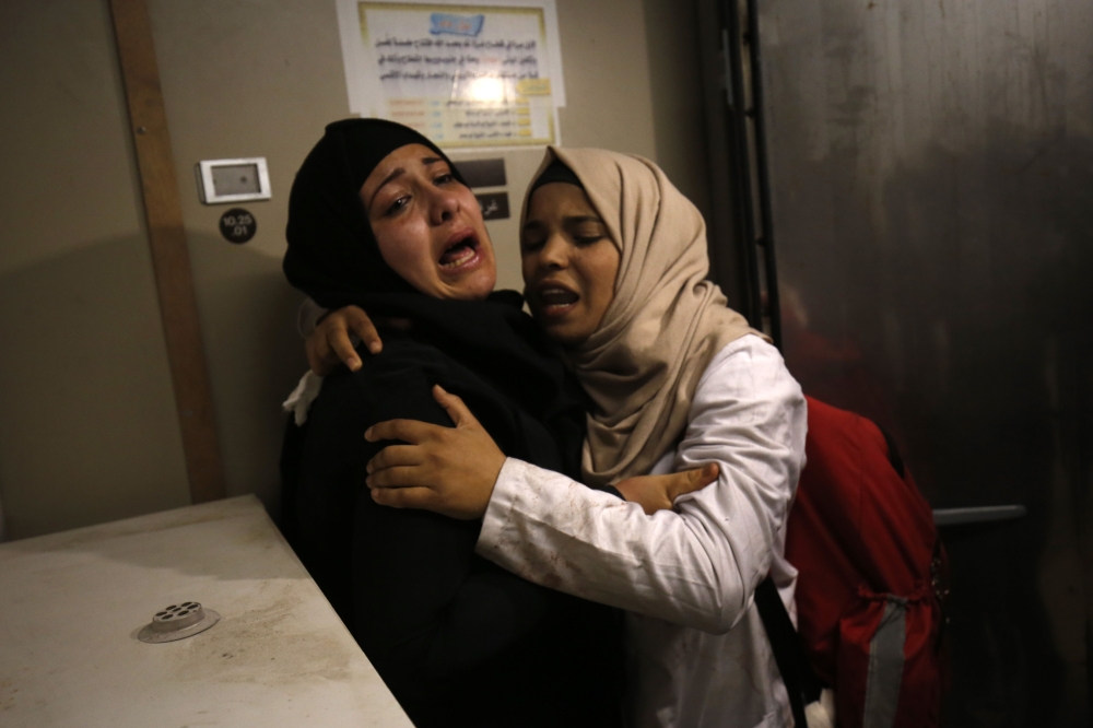 Relatives of Yasser Abu al-Naja, a Palestinian youth in his early teens who was killed in border clashes near Khan Yunis, mourn at a hospital morgue in the Gaza Strip on June 29, 2018. Israeli troops shot dead two Palestinians in border clashes in the southern Gaza Strip, the Hamas-ruled territory's health ministry said. / AFP / SAID KHATIB
