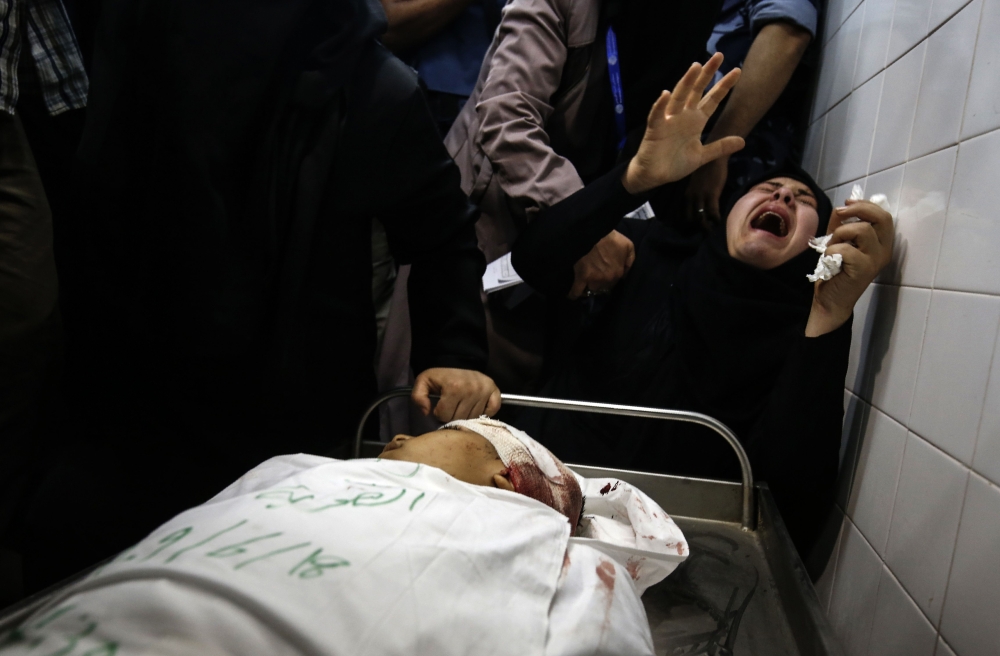 The aunt of Yasser Abu al-Naja, a Palestinian youth in his early teens who was killed in border clashes near Khan Yunis, reacts at a hospital morgue in the Gaza Strip on June 29, 2018. Israeli troops shot dead two Palestinians in border clashes in the southern Gaza Strip, the Hamas-ruled territory's health ministry said. / AFP / SAID KHATIB
