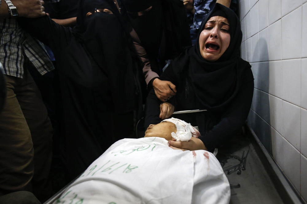 The mother of Yasser Abu al-Naja, a Palestinian youth in his early teens who was killed in border clashes near Khan Yunis, reacts at a hospital morgue in the Gaza Strip on June 29, 2018. Israeli troops shot dead two Palestinians in border clashes in the southern Gaza Strip, the Hamas-ruled territory's health ministry said. / AFP / SAID KHATIB
