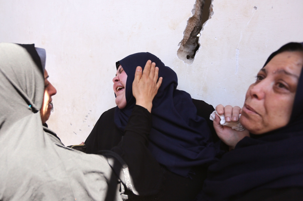 Palestinian relatives of 12 years old Yasser Abu Naja mourn over his death during the funeral in Khan Yunis, in the Southern Gaza Strip on June 30, 2018. The Palestinian youth was shot in the head near the town of Khan Yunis on June 29, according to health Ministry spokesman Ashraf al-Qudra. / AFP / MAHMUD HAMS
