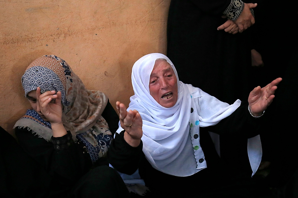 Palestinians mourn over the death of 24-year-old Mohammed al-Hamayda, during his funeral in Rafah in the Southern Gaza Strip on June 30, 2018. Israeli troops shot dead two Palestinians, one in his early teens, in border clashes in the southern Gaza Strip, the Hamas-ruled territory's health ministry said. 24-year-old Mohammed al-Hamayda was fatally wounded in the stomach by Israeli fire in an incident east of Rafah. / AFP / SAID KHATIB
