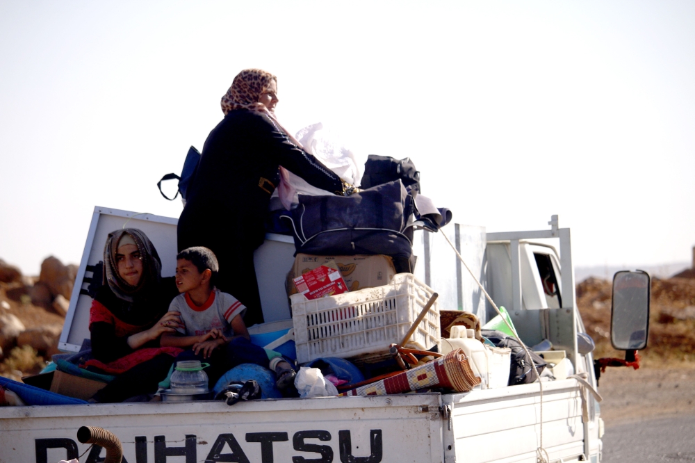 CORRECTION / A Syrian family returns to their homes in towns and villages situated on the eastern outskirts of Daraa on June 6, 2018. The Syrian regime reached a ceasefire deal with rebels in the country's south, the official SANA news agency said. / AFP / Mohamad ABAZEED 