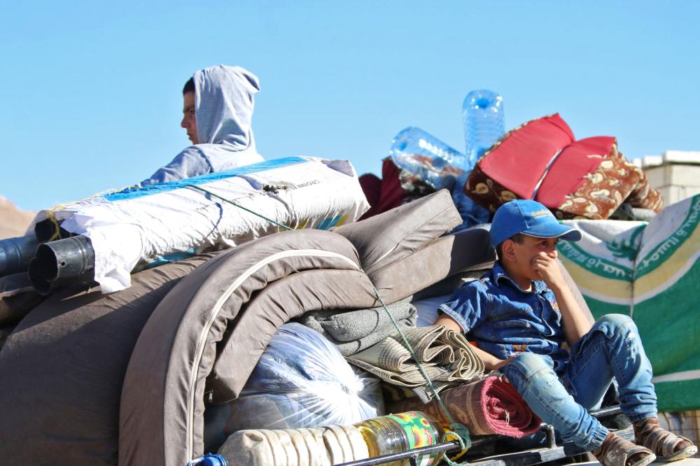 



طفلان سوريان يستقلان سيارة عائلتهما لدى مغادرتها مخيم للاجئين في مدينة عرسال اللبنانية أمس الأول. (أ.ف.ب)