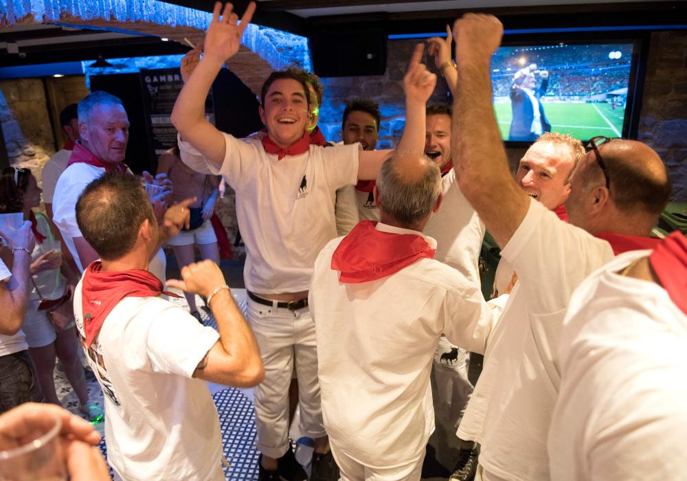 French football supporters celebrate in a tavern of Pamplona on July 10, 2018, during the San Fermin Festival after the victory of French against Belgium in the first semi-final football match of the 2018 Russia World Cup. / AFP / ANDER GILLENEA
