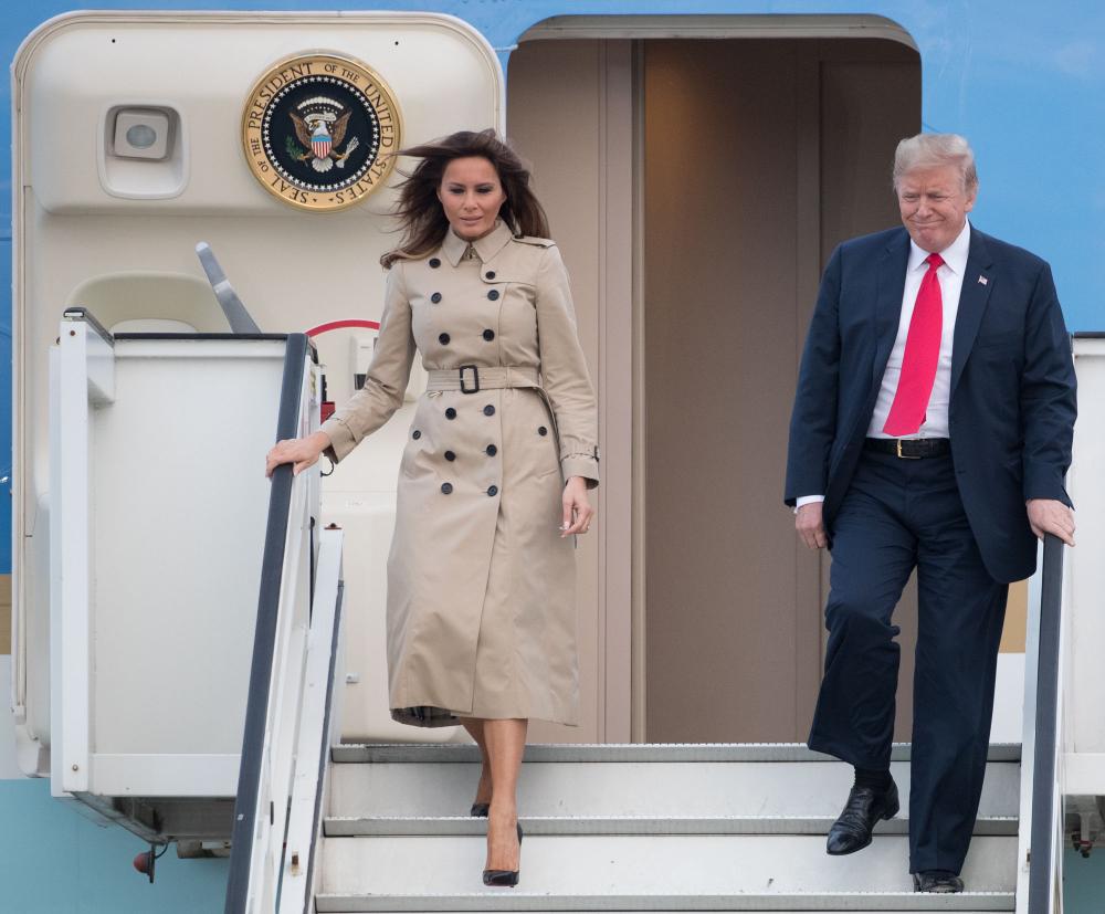 US President Donald Trump (R) and US First Lady Melania Trump disembark from Air Force One as they arrive at Melsbroek Air Base in Haachtsesteenweg on July 10, 2018. US President Donald Trump has arrived in Brussels on the eve of a tense NATO summit where he is set to clash with allies over defence spending. Trump arrived on Air Force One at Melsbroek military airport, shortly after saying on Twitter that NATO allies should 