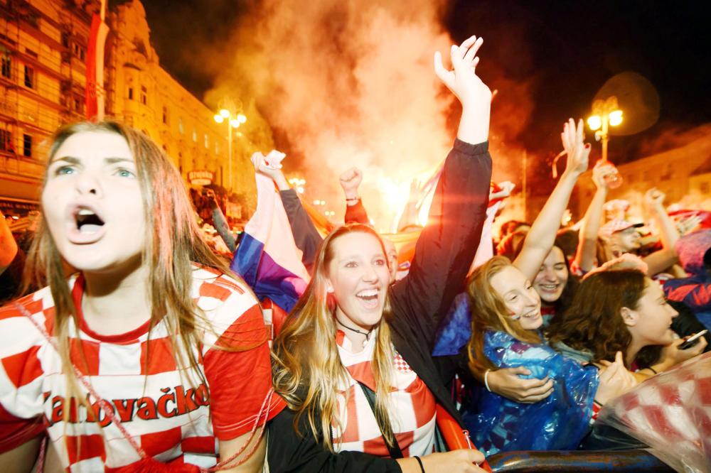 Croatia's supporters celebrate after a goal as they watch on a giant screen the Russia 2018 World Cup semi-final football match between Croatia and England, at the main square in Zagreb on July 11, 2018.  / AFP / Denis Lovrovic
